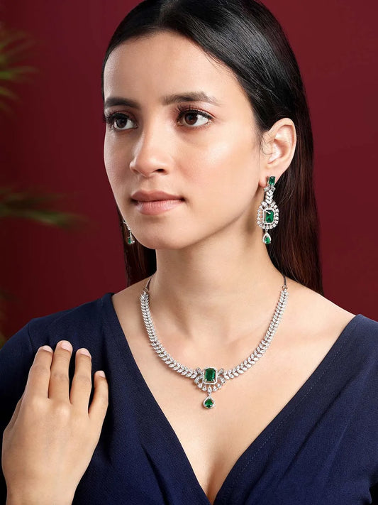 Emerald Elegance Crystal CZ Necklace Set. A silver-colored necklace and earring set with green emerald stones and clear cubic zirconia accents.