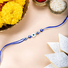 Close-up of Evil Eye Sterling Silver Thread Rakhi featuring blue & white thread, nan work, and rhodium plating – ideal for Raksha Bandhan | Peora
