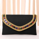 Black clutch bag named Woven Party Clutch with Stone Embellish, featuring faux emerald detailing and soft fabric texture | Peora
