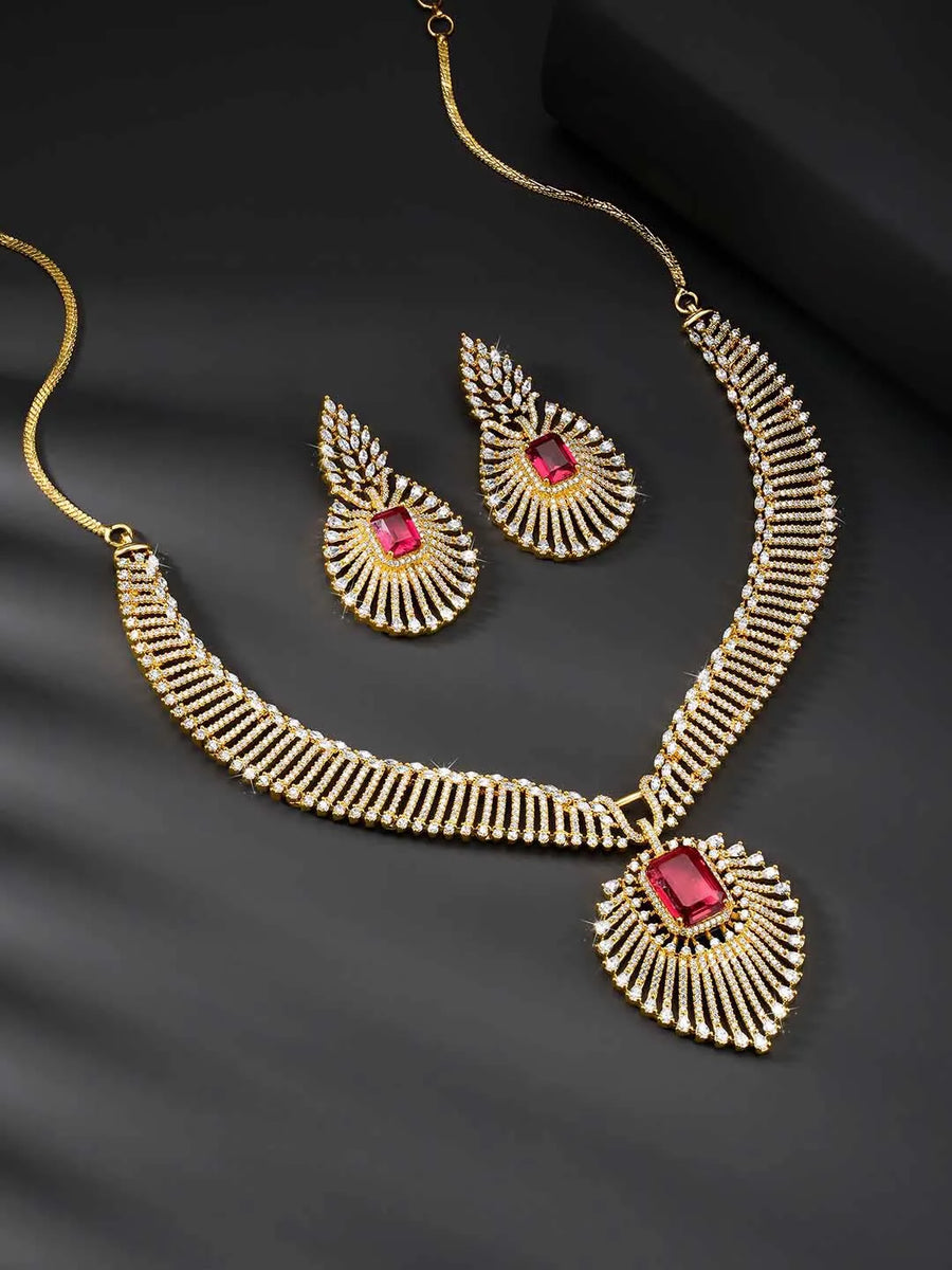 Sparkling Royal Ruby CZ Necklace Set by Peora. Gold-plated necklace set with a geometric pattern and red-colored stones and earrings.