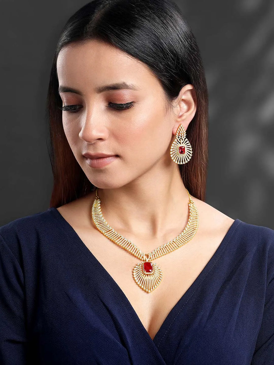 Sparkling Royal Ruby CZ Necklace Set by Peora. Gold-plated necklace set with a geometric pattern and red-colored stones and earrings.