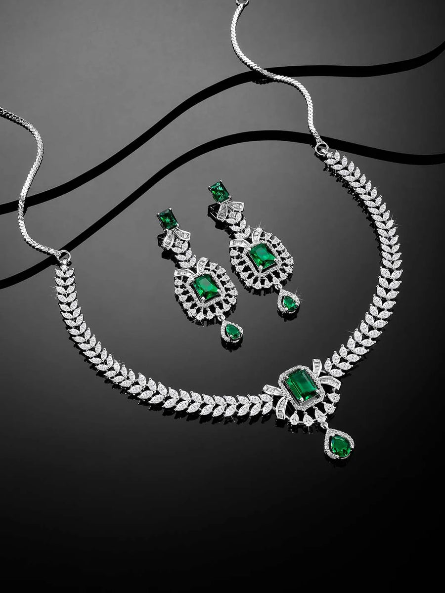 Emerald Elegance Crystal CZ Necklace Set. A silver-colored necklace and earring set with green emerald stones and clear cubic zirconia accents.