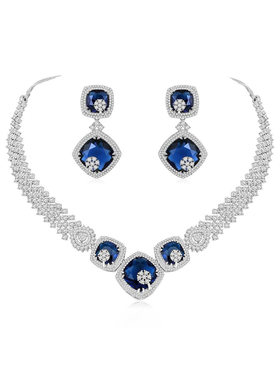 Exquisite CZ Necklace Sets Collection. A silver-colored necklace and earring set with blue and white cubic zirconia stones.