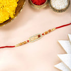 Close-up of Rudraksha Rakhi with Shree Ram with red thread, adorned with crystals & beads and finished in gold plating | Peora
