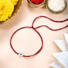 Close-up of Protective Evil Eye & CZ Silver Rakhi featuring maroon thread, cubic zirconia work, and rhodium plating – ideal for Raksha Bandhan | Peora
