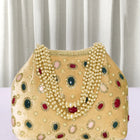 Gold potli bag named Embellished Ethnic Potli with Pearls, featuring faux emerald detailing and soft fabric texture | Peora
