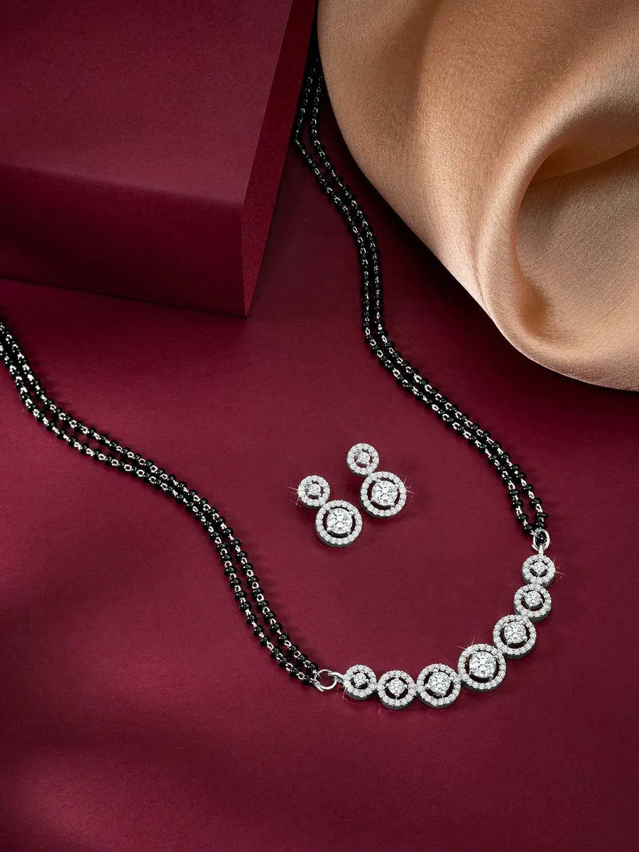 Luxurious Gleaming CZ Mangalsutra Set. Mangalsutra and matching earrings with cubic zirconia stones along with silver plating.
