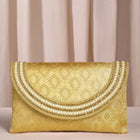 Gold clutch bag named Twilight Gleam Foldover Clutch, featuring pearl detailing and soft fabric texture | Peora
