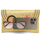 Gold clutch bag named Twilight Gleam Foldover Clutch, featuring pearl detailing and soft fabric texture | Peora
