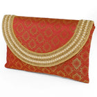 Maroon clutch bag named Twilight Gleam Foldover Clutch, featuring pearl detailing and soft fabric texture | Peora
