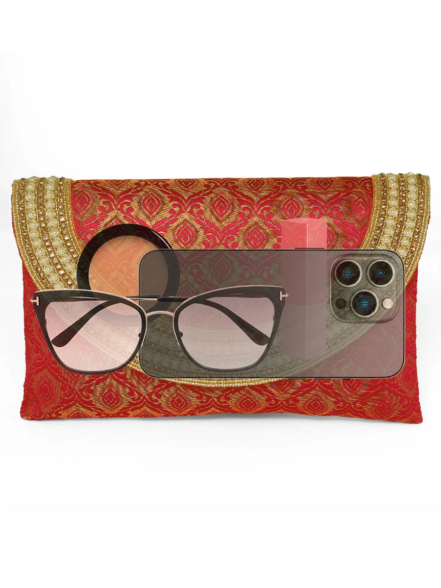 Maroon clutch bag named Twilight Gleam Foldover Clutch, featuring pearl detailing and soft fabric texture | Peora

