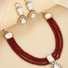 Graceful Layers with Kundan Set. Gold-plated red beaded necklace set with large white stones and matching drop earrings.