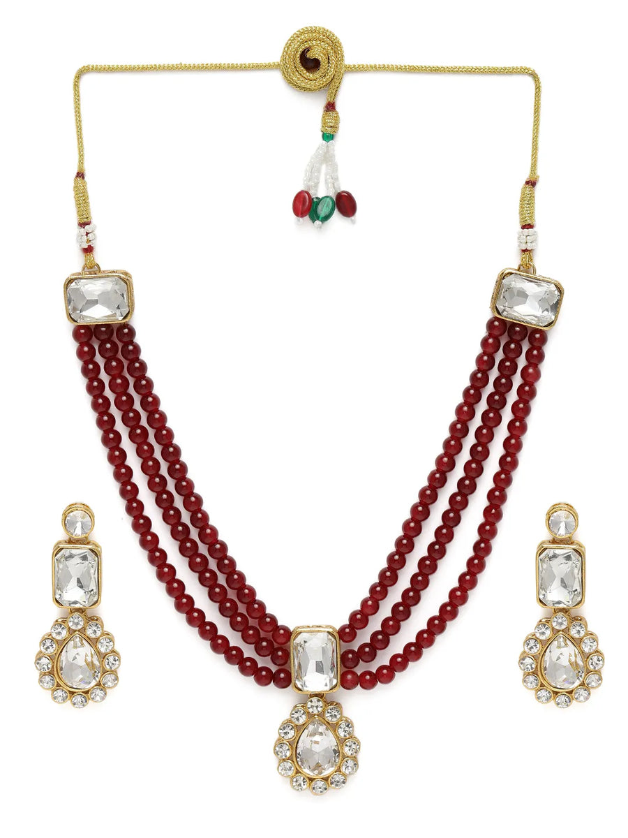 Graceful Layers with Kundan Set. Gold-plated red beaded necklace set with large white stones and matching drop earrings.