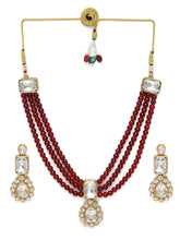 Graceful Layers with Kundan Set. Gold-plated red beaded necklace set with large white stones and matching drop earrings.