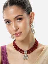 Graceful Layers with Kundan Set. Gold-plated red beaded necklace set with large white stones and matching drop earrings.