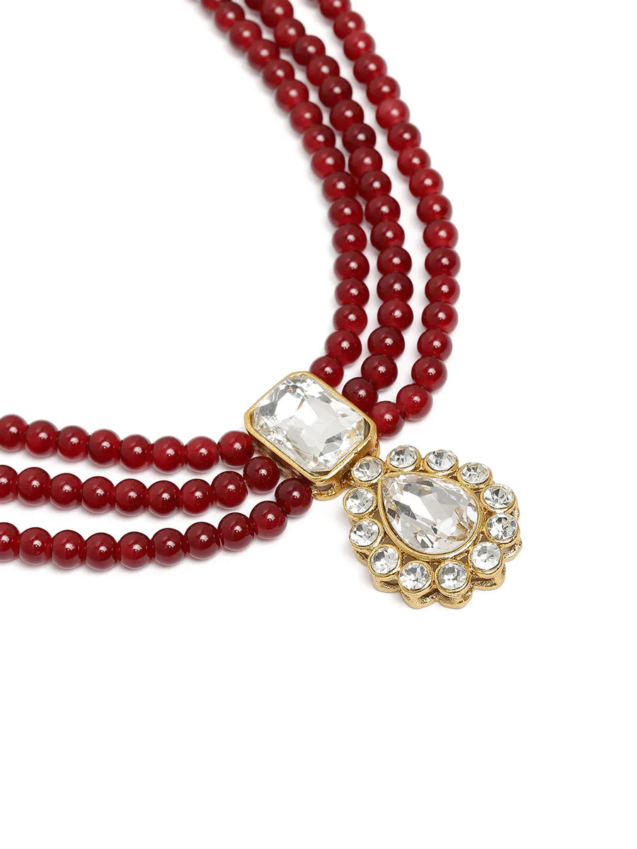 Graceful Layers with Kundan Set. Gold-plated red beaded necklace set with large white stones and matching drop earrings.