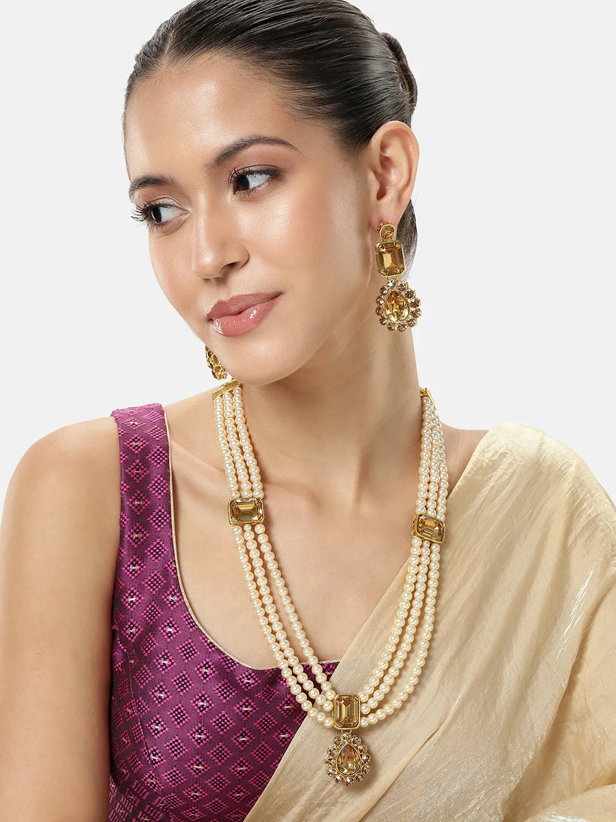 Gracefully Layered Kundan Necklace Set. Gold and pearl necklace set with matching drop earrings featuring rectangular stones and floral motifs.