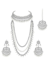 Bridal Splendour Kundan Pearls Set. Silver-plated layered bridal necklace set with pearls, kundan and matching earrings, complemented by a maang tikka.