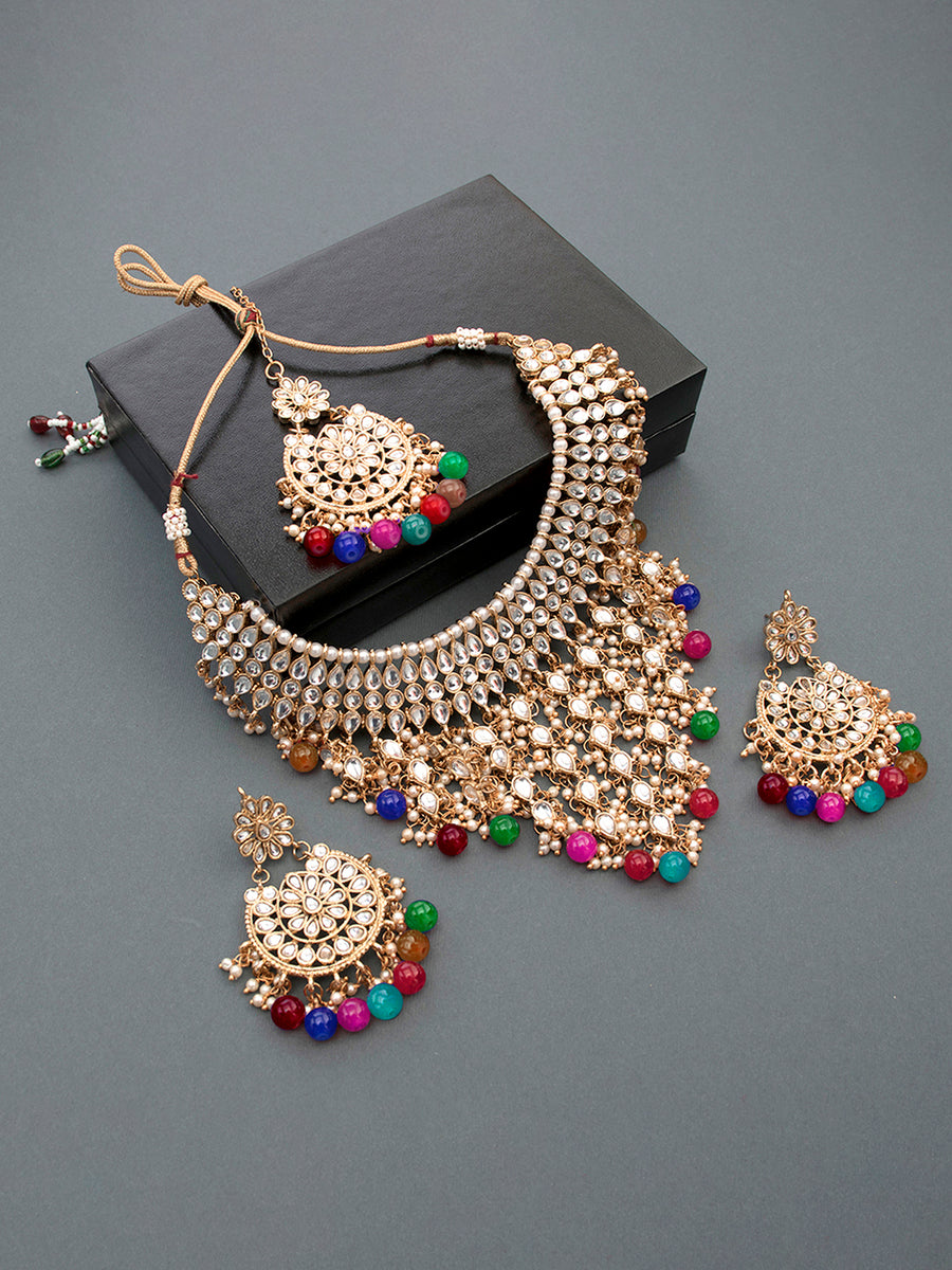 Bridal Bliss Kundan Pearl Necklace Set. Gold-plated Kundan bridal necklace set with colorful beads, matching jhumka earrings, and maang tikka. Perfect for weddings and festive occasions.