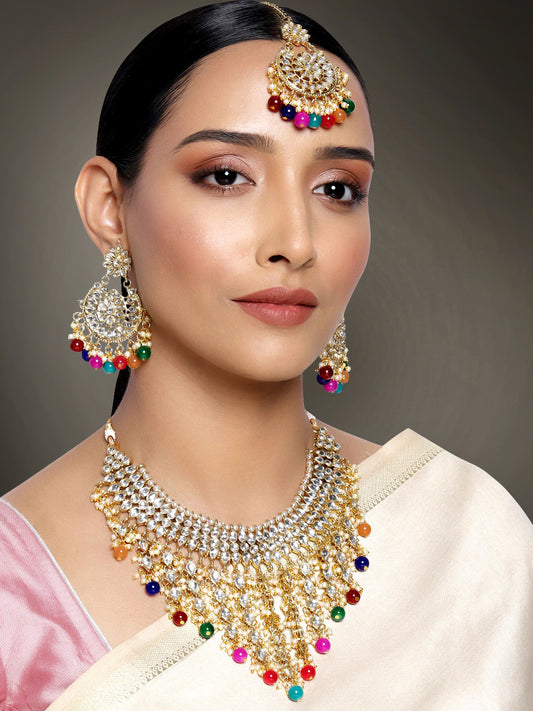 Bridal Bliss Kundan Pearl Necklace Set. Gold-plated Kundan bridal necklace set with colorful beads, matching jhumka earrings, and maang tikka. Perfect for weddings and festive occasions.