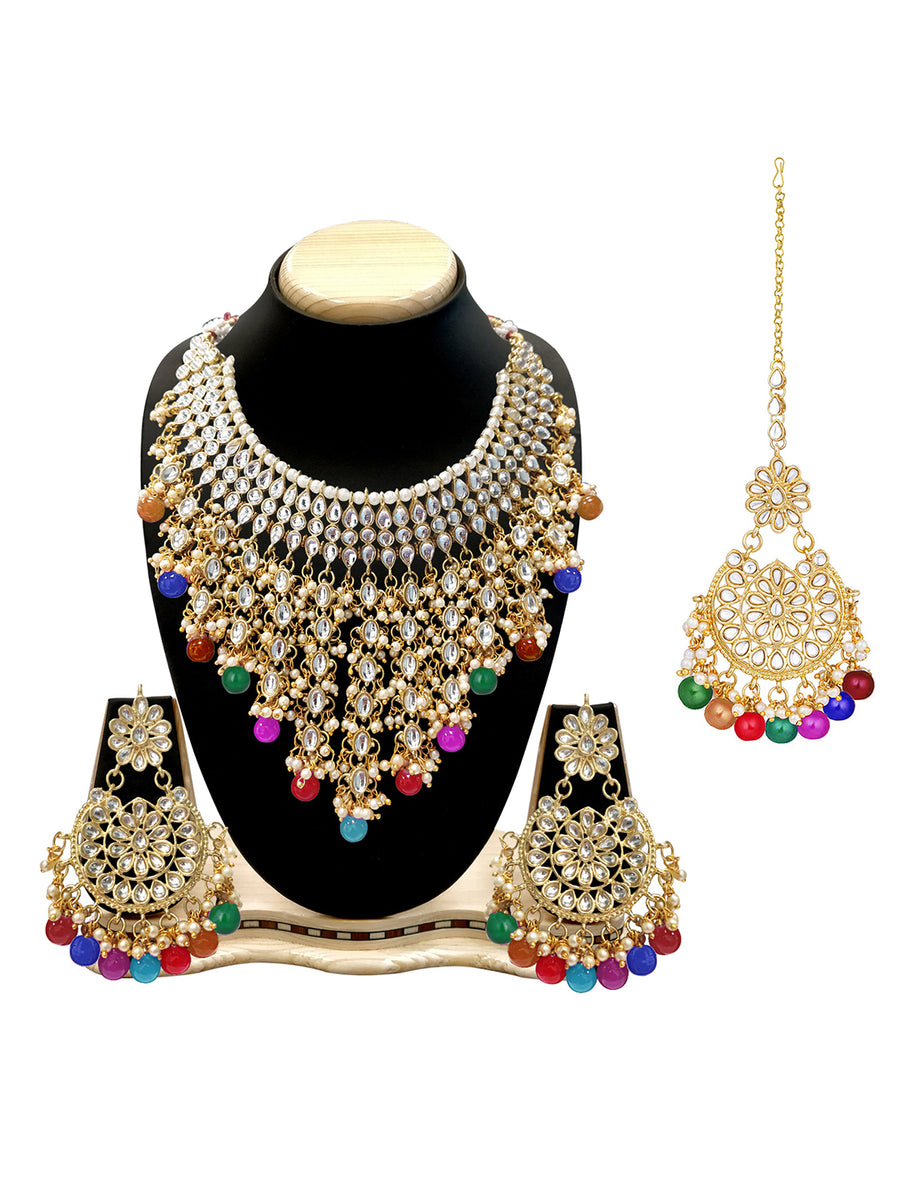 Bridal Bliss Kundan Pearl Necklace Set. Gold-plated Kundan bridal necklace set with colorful beads, matching jhumka earrings, and maang tikka. Perfect for weddings and festive occasions.