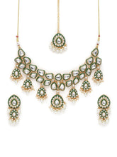 Pearled Petals Kundan Wedding Set. Gold and green Kundan necklace set with pearls, matching earrings, and maang tikka ideal for festive and traditional wear.