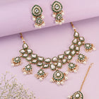 Pearled Petals Kundan Wedding Set. Gold and green Kundan necklace set with pearls, matching earrings, and maang tikka ideal for festive and traditional wear.