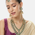 Kundan Majesty Double Layer Set. Gold and green double-layer Kundan necklace set with pearls, matching jhumka earrings, and maang tikka – perfect for festive and traditional wear.