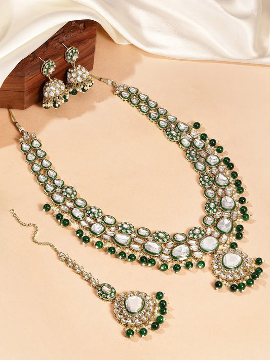 Nature's Glisten Green Necklace Set by Peora. Gold-plated green Kundan necklace set with matching earrings and maang tikka, featuring green beads & white pearls.