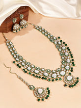Nature's Glisten Green Necklace Set by Peora. Gold-plated green Kundan necklace set with matching earrings and maang tikka, featuring green beads & white pearls.