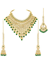 Royal Beads & Kundan Bridal Set. Gold jewellery set, pair of earrings & maangtikka embellished with with Kundan, green stones along with pearls. Prefect for your wedding day by peora.