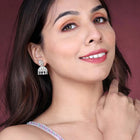 Luxurious Elegance CZ Jhumki Earrings. A pair of silver-colored CZ jhumki earrings with intricate designs and teardrop-shaped stones.