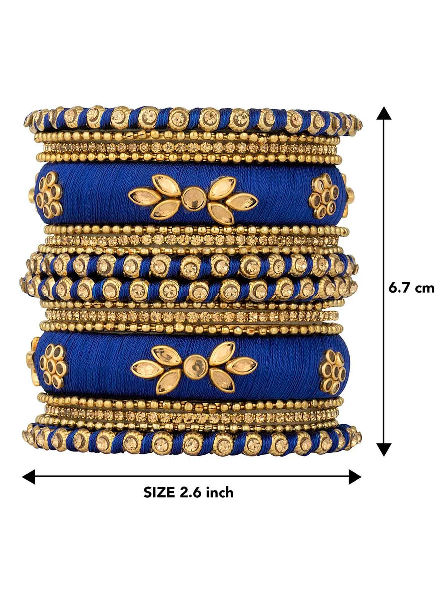 A set of blue and gold colored alloy bangles with kundan embellishments displayed on a cylindrical object.
