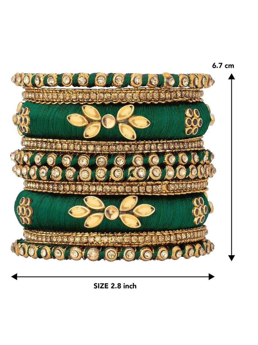 A set of Green and gold colored alloy bangles with kundan embellishments displayed on a cylindrical object.
