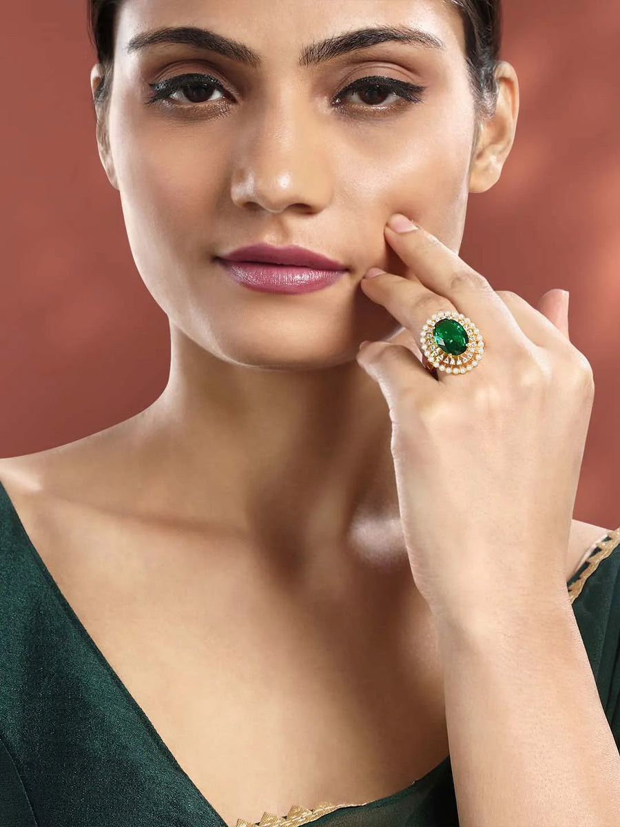 Opulent Green CZ Statement Ring by Peora. Adjustable ring with a gold-plating band and smaller white stones, pearls around the green centrepiece.