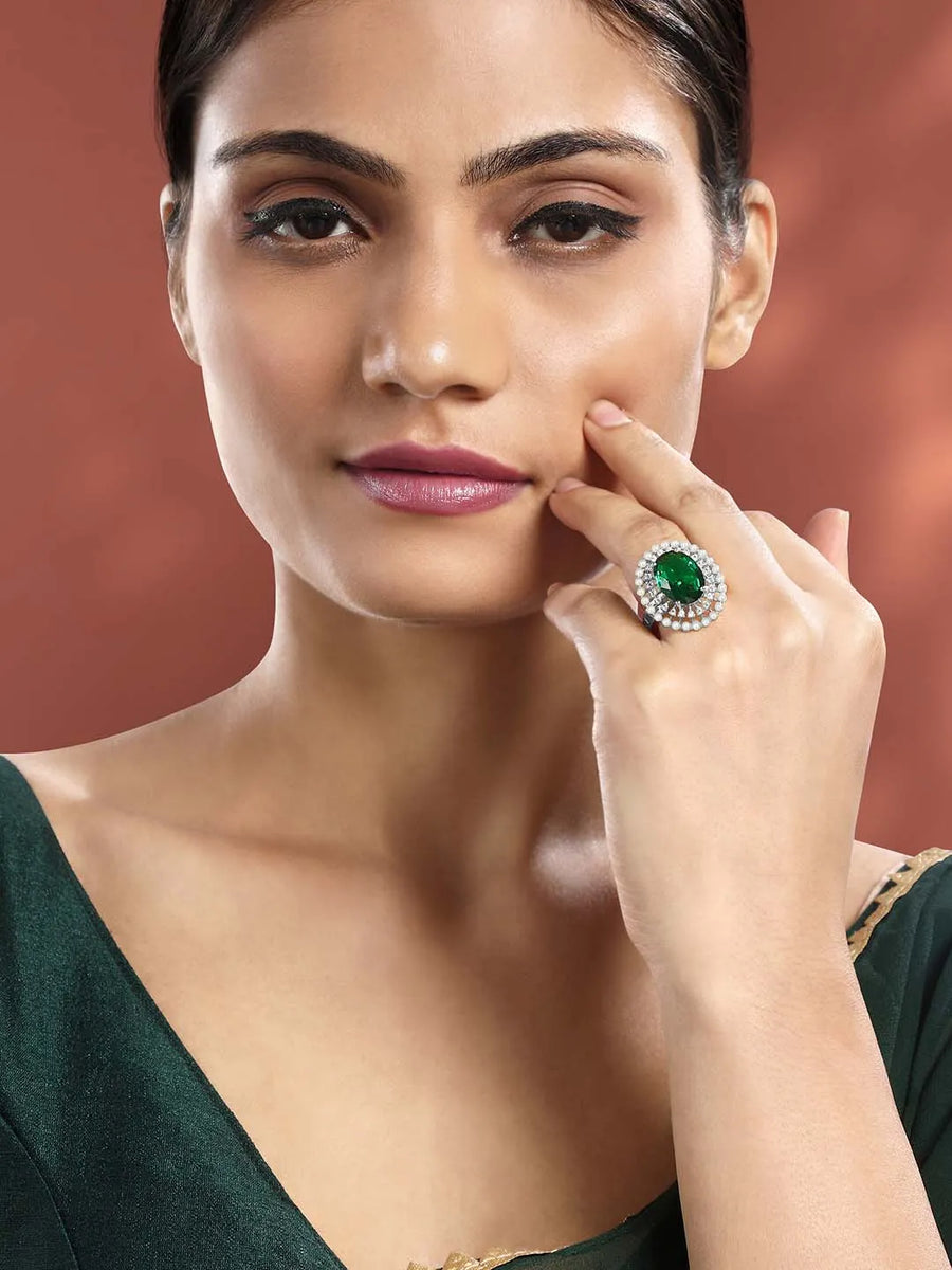 Opulent Green CZ Statement Ring by Peora. Adjustable ring with a silver-plating band and smaller white stones, pearls around the green centrepiece.