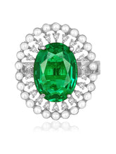 Opulent Green CZ Statement Ring by Peora. Adjustable ring with a silver-plating band and smaller white stones, pearls around the green centrepiece.