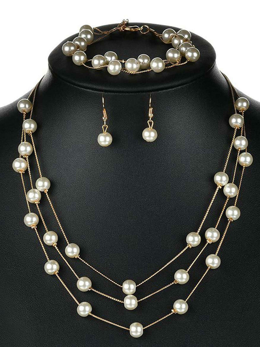 Timeless Glow Pearl Necklace Set featuring white pearls with gold-plated chain, matching bracelet, and earrings