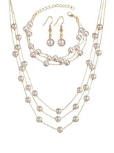 Timeless Glow Pearl Necklace Set featuring white pearls with gold-plated chain, matching bracelet, and earrings