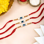 Close-up of Graceful Evil Eye Set of 3 Rakhis featuring red - blue thread, beads work, and gold plating – ideal for Raksha Bandhan | Peora
