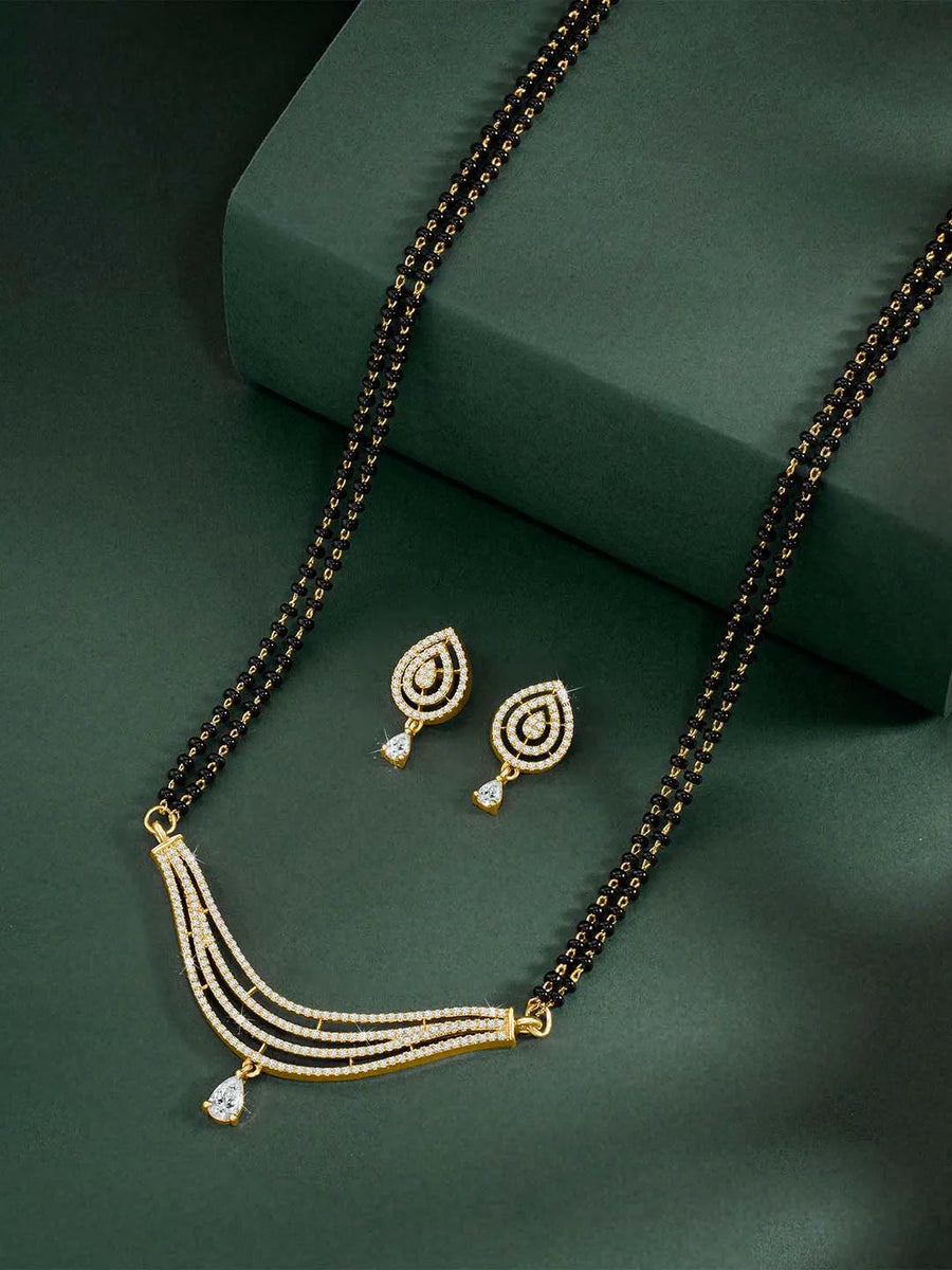 CZ Studded Traditional Mangalsutra Set. A traditional mangalsutra set with black beads and gold-color plating, zirconia stones, & matching earrings.