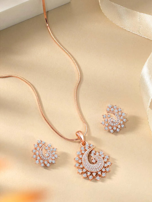 A set of rose gold jewelry including a paisley-shaped pendant necklace and matching earrings, both adorned with cubic zirconia.