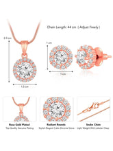 A rose gold-colored pendant necklace with a round cubic zirconia solitaire pendant accompanied by a pair of matching earrings, displayed on a pink cushion.