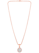 A rose gold-colored pendant necklace with a round cubic zirconia solitaire pendant accompanied by a pair of matching earrings, displayed on a pink cushion.