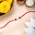Close-up of Silver Tied Rudraksh Rakhi Thread featuring red thread, beads work, and rhodium plating – ideal for Raksha Bandhan | Peora
