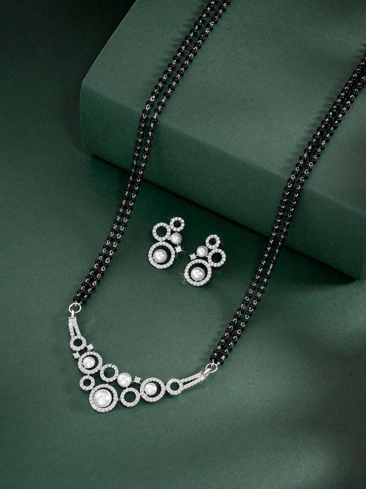 Beautiful Shimmering CZ Mangalsutra Set. A set of black beaded Mangalsutra with silver-colour and geometric patterns, with pearls, CZ stones.