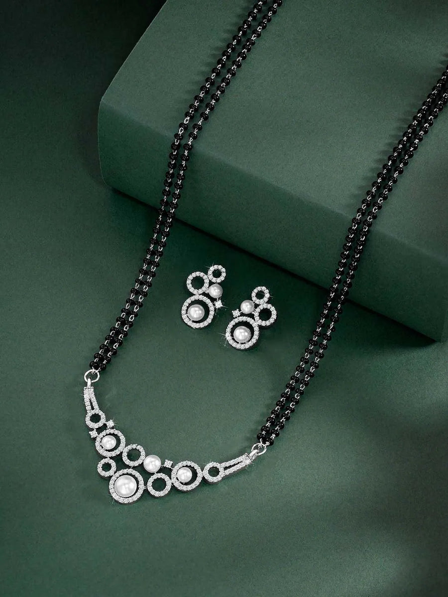 Beautiful Shimmering CZ Mangalsutra Set. A set of black beaded Mangalsutra with silver-colour and geometric patterns, with pearls, CZ stones.