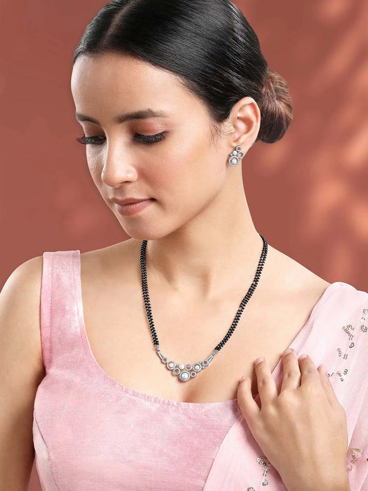 Beautiful Shimmering CZ Mangalsutra Set. A set of black beaded Mangalsutra with silver-colour and geometric patterns, with pearls, CZ stones.