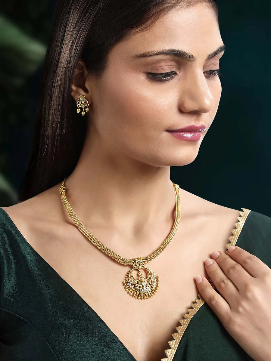 Radiant Elegance Golden Necklace Set. A golden necklace set with intricate designs, consisting of necklace and matching earrings.