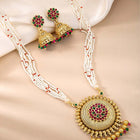 A traditional Indian necklace set with gold-colored metalwork and synthetic stones, accompanied by matching earrings, displayed on a white fabric surface.